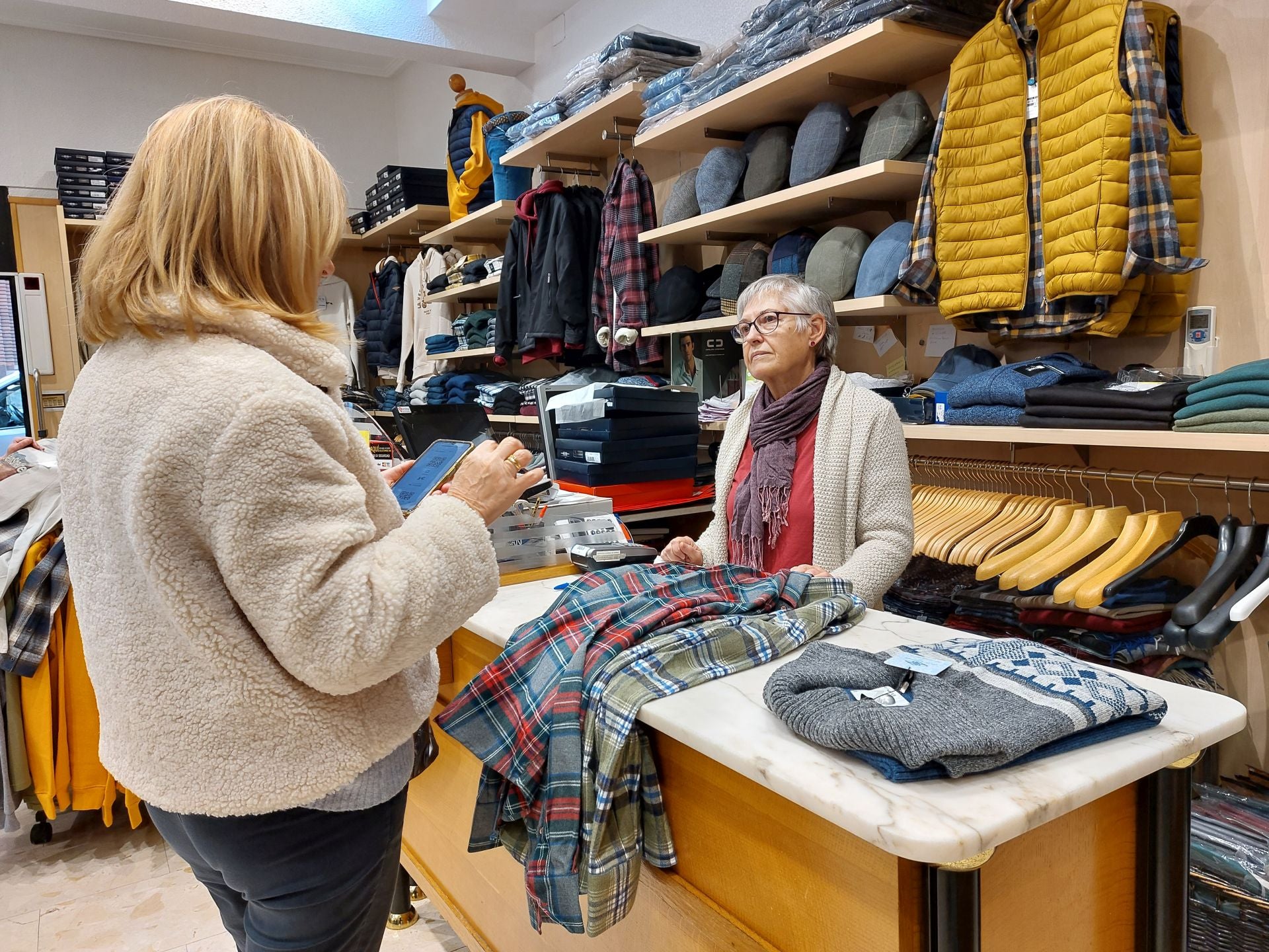 Una clienta se dispone a canjear un bono en un tienda de ropa de caballero.