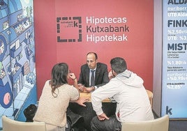 Clientes de un banco consultan con un asesor hipotecario.