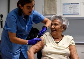 Una mujer recibe la vacuna de la gripe.