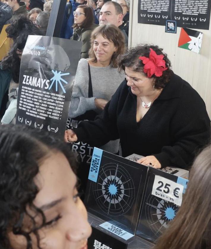 Imagen secundaria 2 - El cantante y guitarra de ETS, Iñigo Etxezarreta, charla con unas fans. Y Josune Arakistain y Aiora Renteria firman sus trabajos a unas seguidoras. 