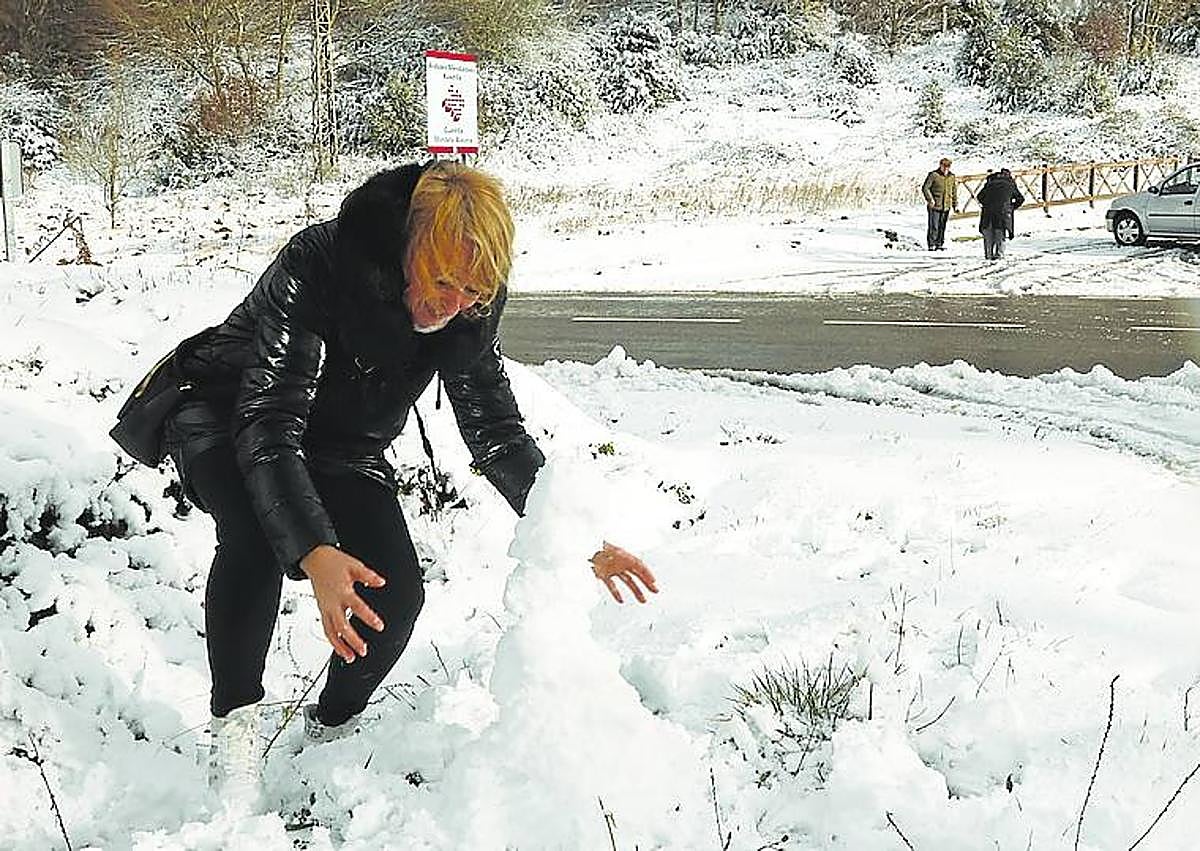 Imagen secundaria 1 - Arriba, la arena de la playa de Ereaga cubrió el paseo y la carretera que discurren en paralelo al arenal. Abajo a la izquierda, nieve en el puerto de Herrera. Y a la derecha, el viento y la lluvia volvieron ayer a ser protagonistas. 