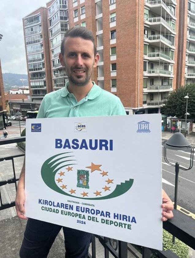 El concejal de Deportes Jon Zugazagoitia posa con el cartel que acredita a Basauri como Ciudad Europea del Deporte