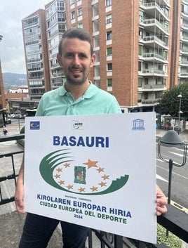 El concejal de Deportes Jon Zugazagoitia posa con el cartel que acredita a Basauri como Ciudad Europea del Deporte