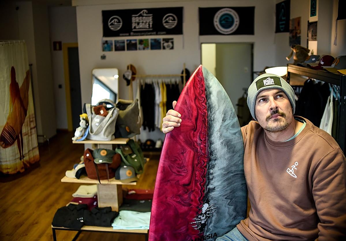 Gonzalo Astorqui posa, tabla en mano, en su nueva tienda de Getxo de estilo surfero llena de moda local.