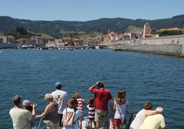 Un grupo de turistas regresa a Bermeo tras recorrer la costa en barco.