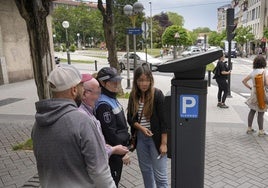 Unos vecinos aprenden a manejar un parquímetro de la OTA