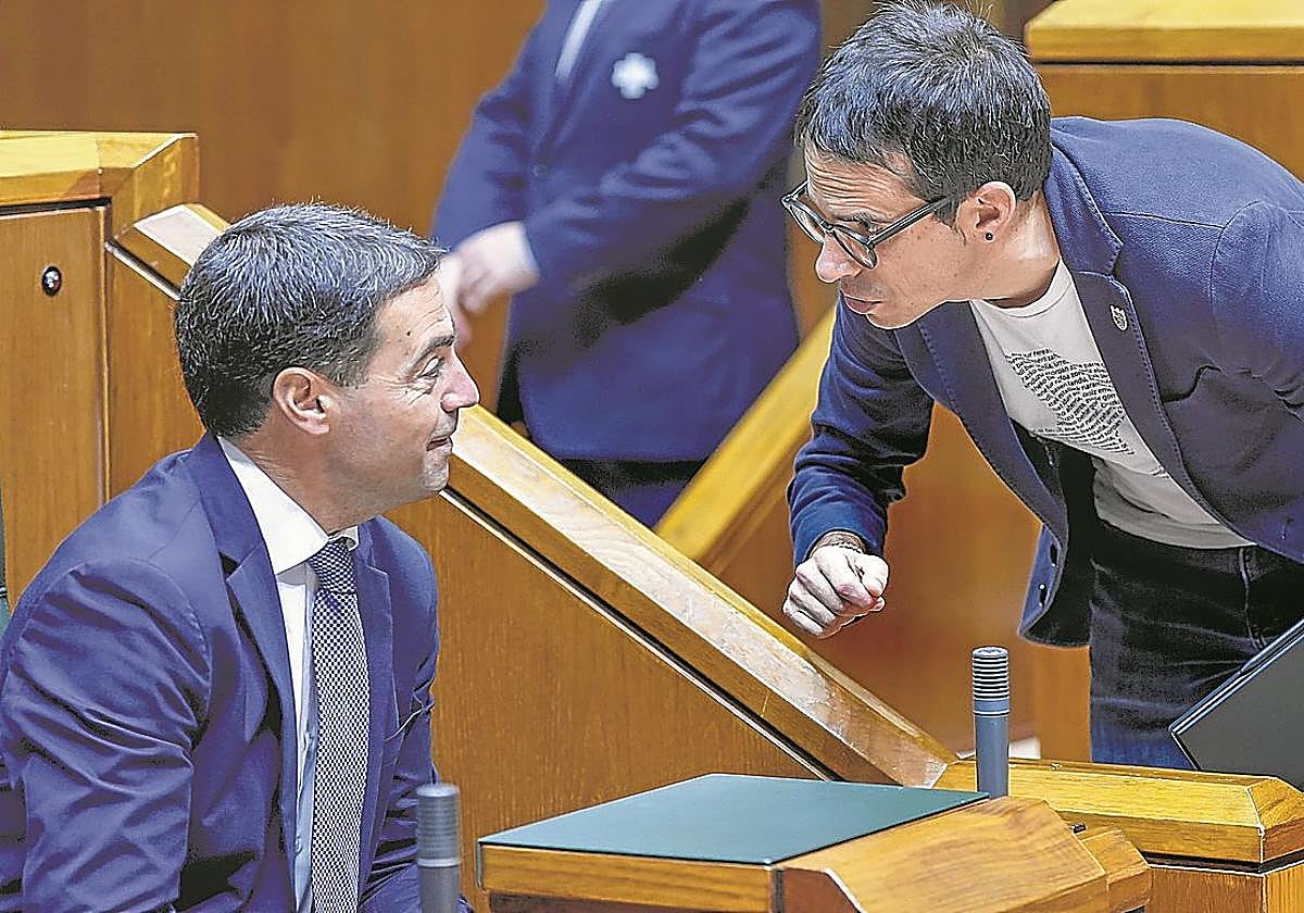 Imanol Pradales charla con Pello Otxandiano durante un pleno en el Parlamento vasco.