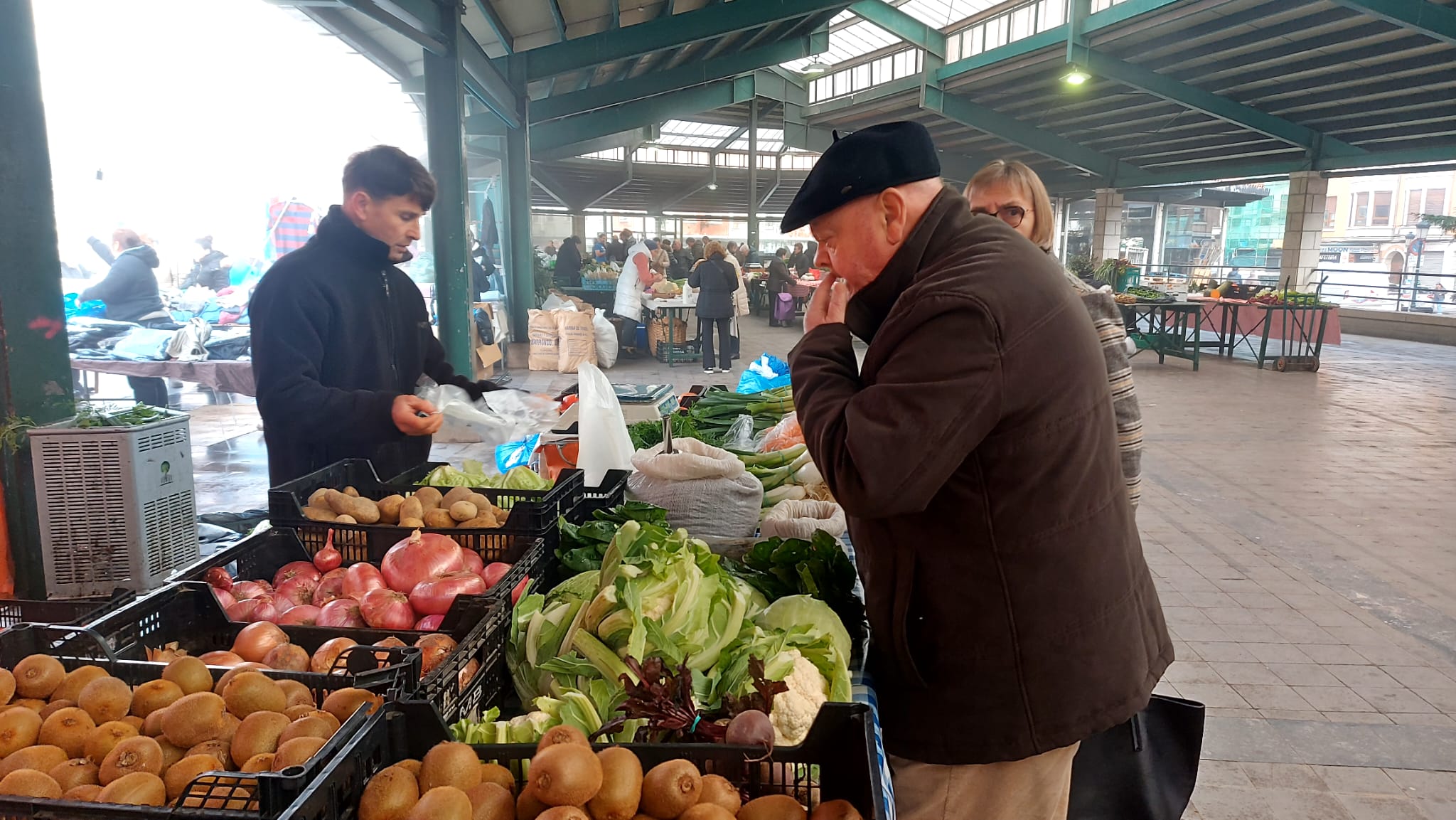 Varios clientes llenan la cesta de la compra en el mercado semanal de Gernika.