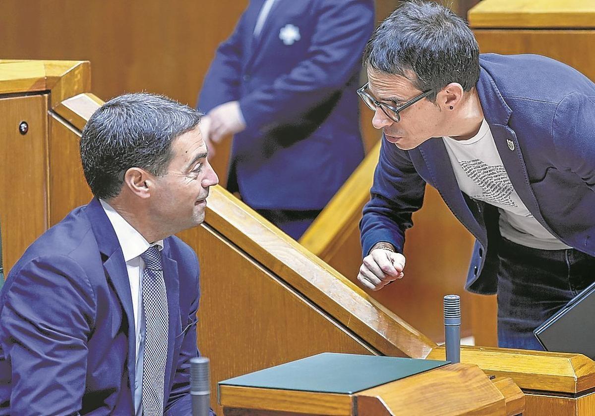 Imanol Pradales charla con Pello Otxandiano durante un pleno en el Parlamento vasco.