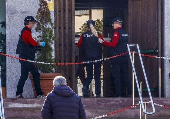 Agentes de la Ertzaintza acceden al interior de la residencia donde se produjo el homicidio.