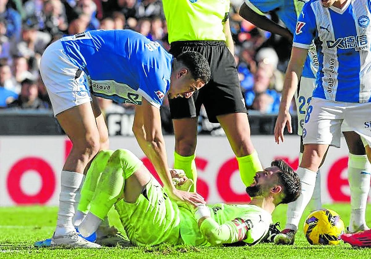 Abqar se interesa por Sivera, con evidentes gestos de dolor, sobre el césped de Mestalla.