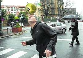 Igor Oca juega con un balón en la Gran Vía de Bilbao.