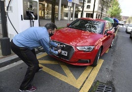 Carga de un vehículo eléctrico junto a la Torre Iberdrola, en Bilbao.