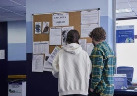 Dos jóvenes revisan los cursos de inserción laboral en la sede de Behargintza de Leioa.