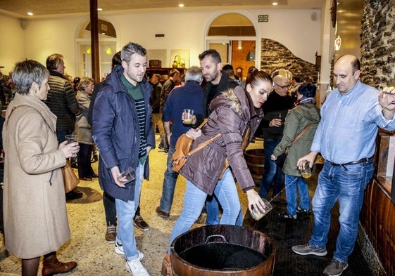 Una cuadrilla llena sus vasos de sidra en Kuartango.