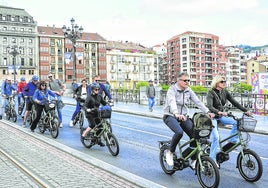 Un grupo de turistas atraviesa el Puente del Arenal en bicicleta.