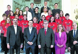 Las atletas del Bilbao Atletismo Santutxu posan en la escalinata del Ayuntamiento con autoridades y patrocinadores.