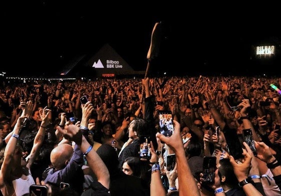 Win Butler (Arcade Fire), guitarra en alto, entre el público.