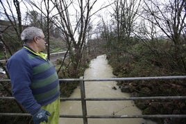 Un vecino observa el caudal del río Mape, en Busturia.