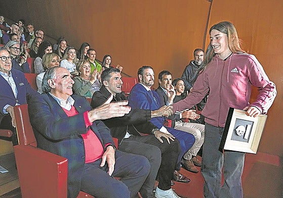 José Ángel Iribar y Dani Vivián felicitan con un choque de manos a la skater bermeotarra Naia Laso al bajar del escenario del Guggenheim con su premio.