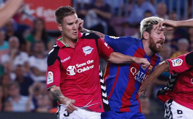 Raúl García pugna un balón con Leo Messi.