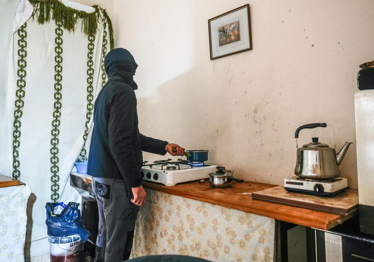 El cabeza de familia hierve unos huevos en la cocina que ha instalado en la lonja okupada de la calle Bruno Villarreal.