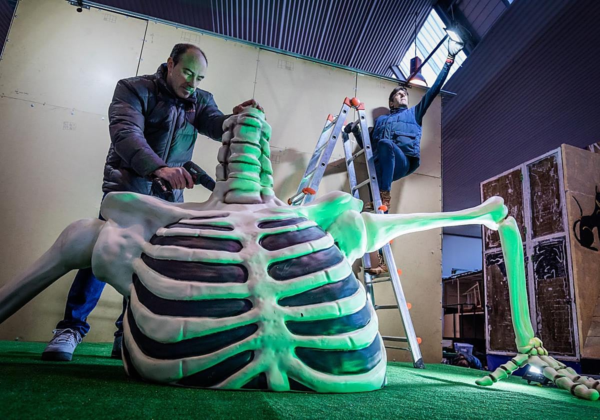 Dos personas trabajan en el atrezzo de la comparsa.