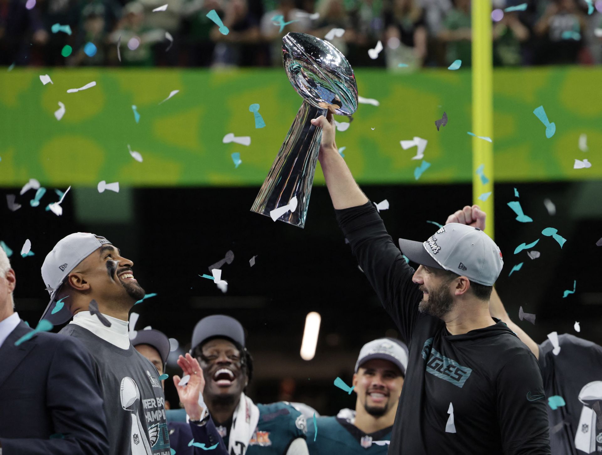 El entrenador en jefe de los Eagles, Nick Sirianni, levanta el trofeo Vince Lombardi ante la mirada de su quarterback, Jalen Hurts.
