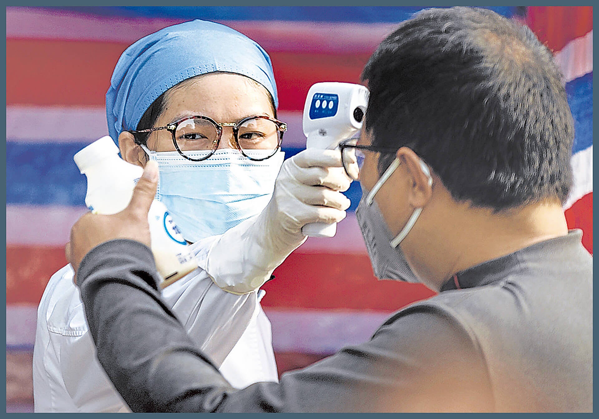 Una sanitaria comprueba la temperatura corporal de un ciudadano en Guangzhou, en China.
