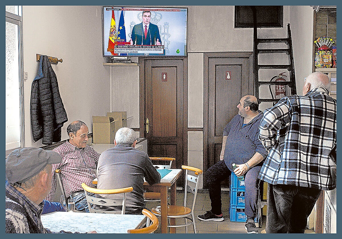 Restricciones. Clientes de un bar de Orense siguen la comparecencia de Sánchez en la que declaró el estado de alarma.