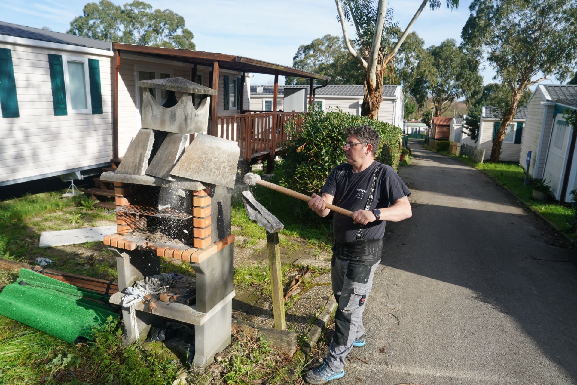 Víctor, uno de los vecinos perjudicados del camping, destruye la barbacoa situada junto a su módulo.