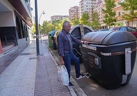 Un ciudadano deposita los residuos en el contenedor marrón.