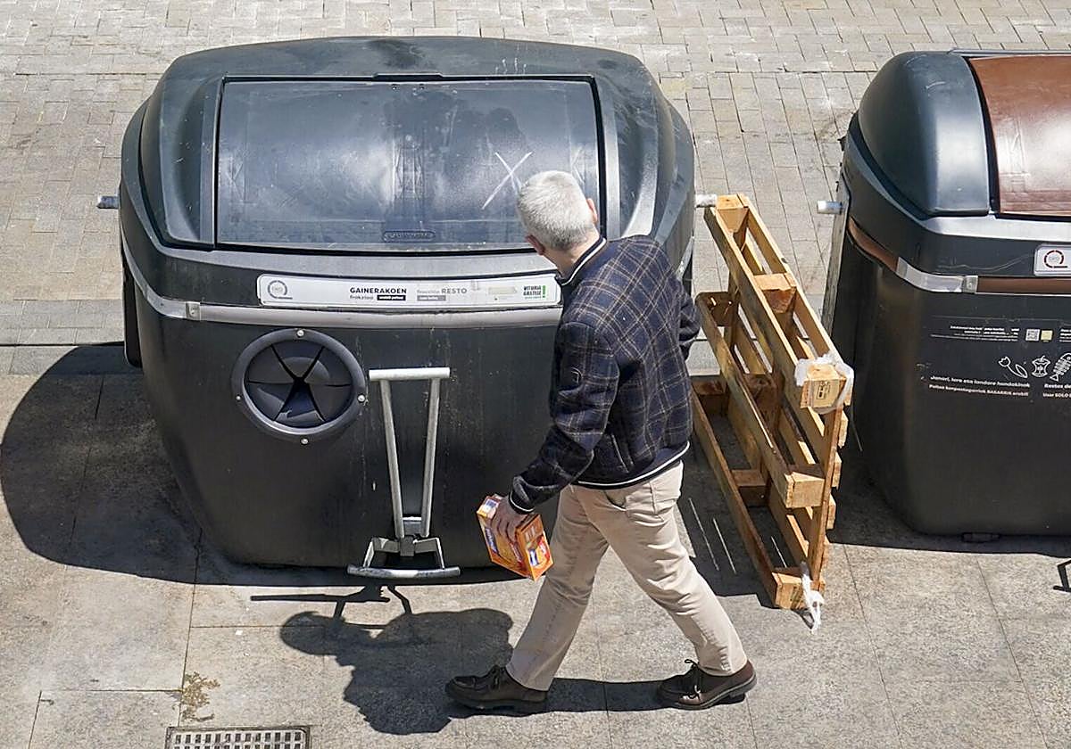 Un hombre pasa junto al contenedor.