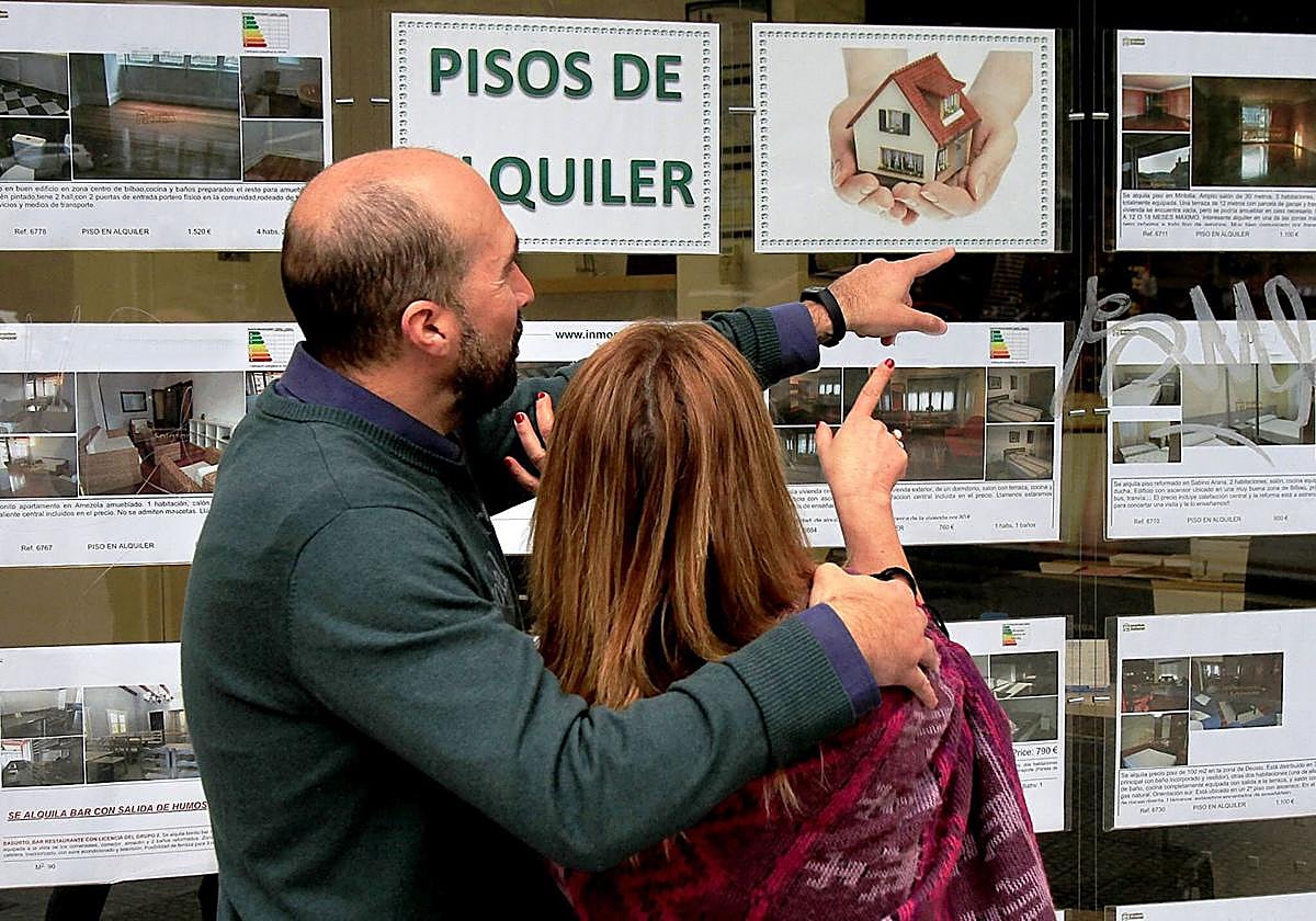 Una pareja ojea anuncios de alquileres en el centro de Bilbao.