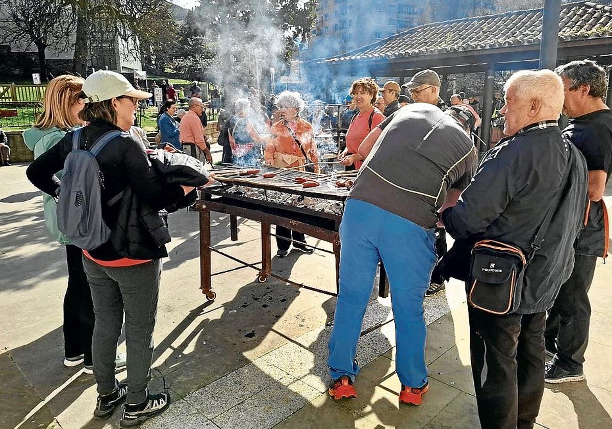 Una vez dieron la vuelta a la presa de Aixola los y las caminantes asaron su chorizo en las parrillas instaladas en la plaza 8 de Marzo.