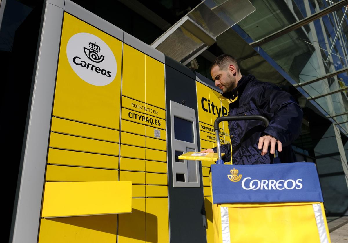 Un trabajador de Correos, ajeno a la información, durante su jornada de reparto.