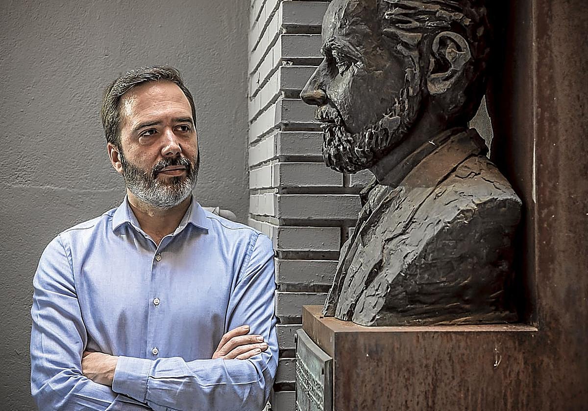 Javier Hurtado observa el busto de Fernando Buesa en el sede del PSE en Vitoria.