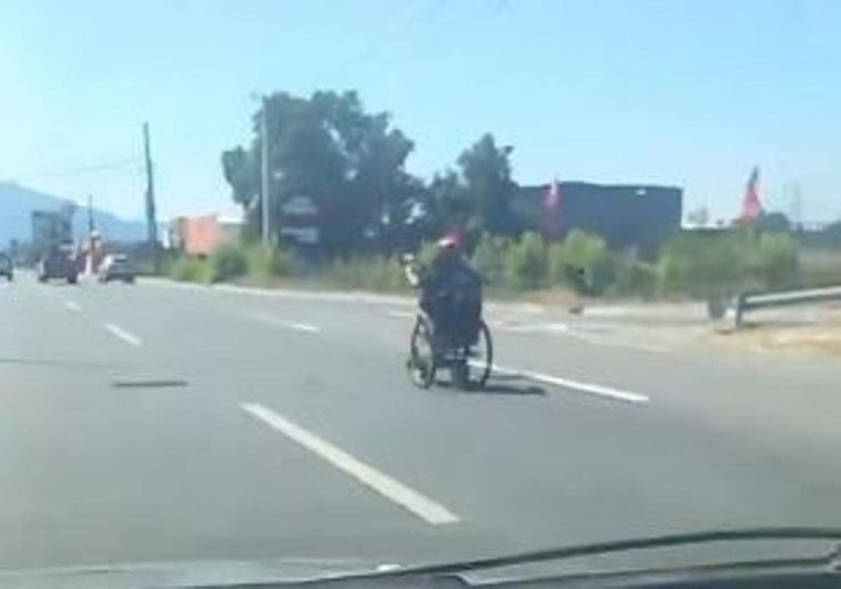 Un hombre circula con una silla de ruedas a 90km/h por una autopista
