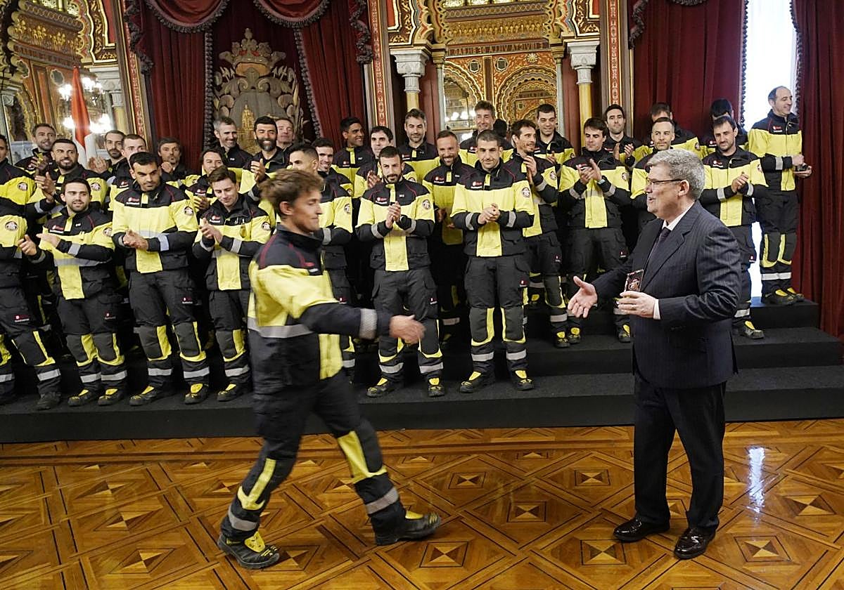 El alcalde entrega su insignia a uno de los 56 bomberos que han pasado a ser funcionarios.