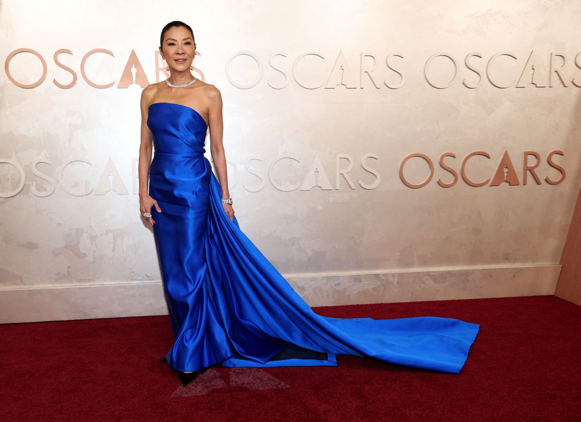 Michelle Yeoh aprueba con nota con este vestido azul eléctrico con escote palabra de honor y larga cola de Balenciaga, firma de la que es imagen. Un sí rotundo.