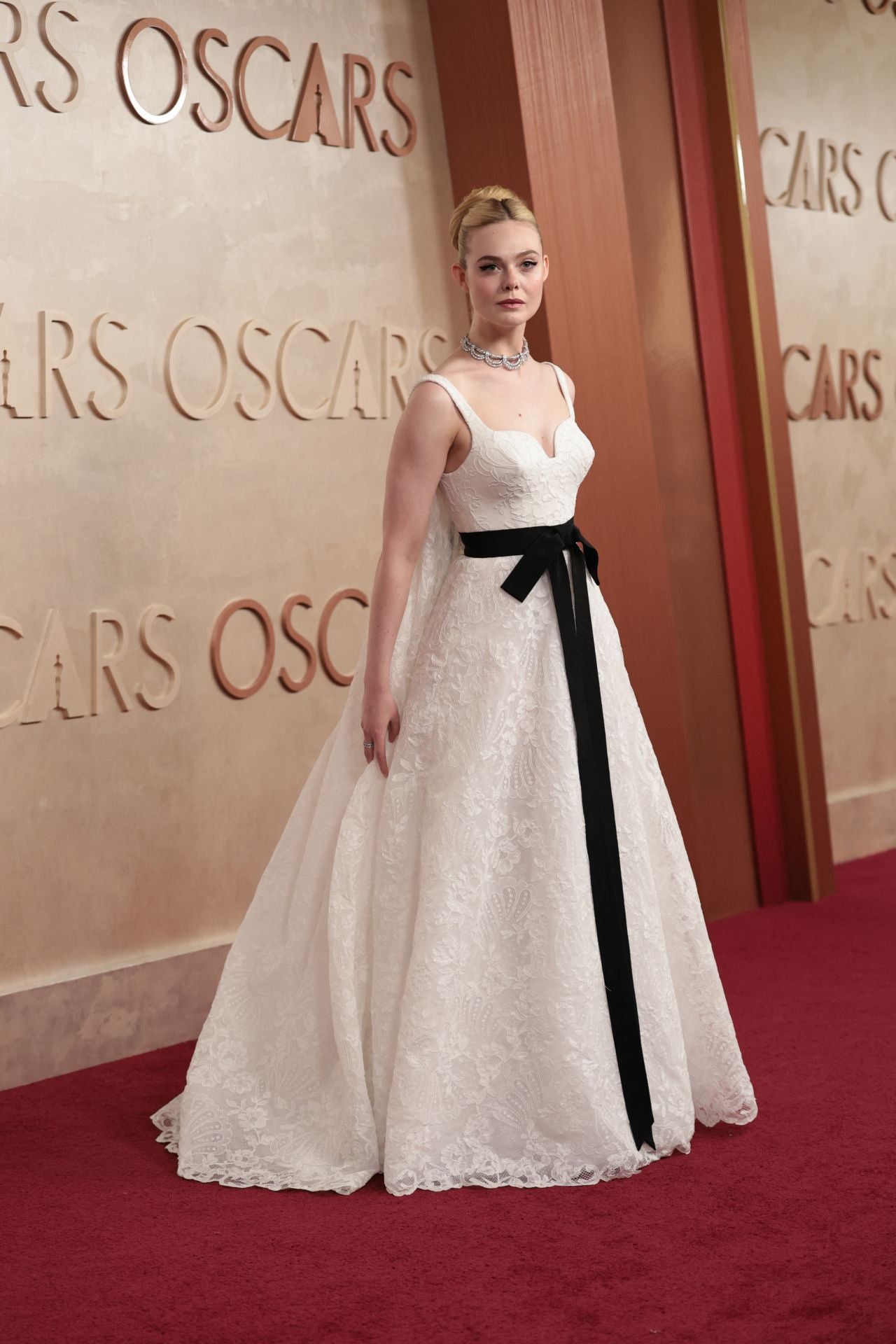 Elle Fanning ha apostado por el siempre elegante binomio blanco y negro con este vestido de encaje con lazada creado para ella por la firma Givenchy. Lo ha completado con joyas de Cartier.
