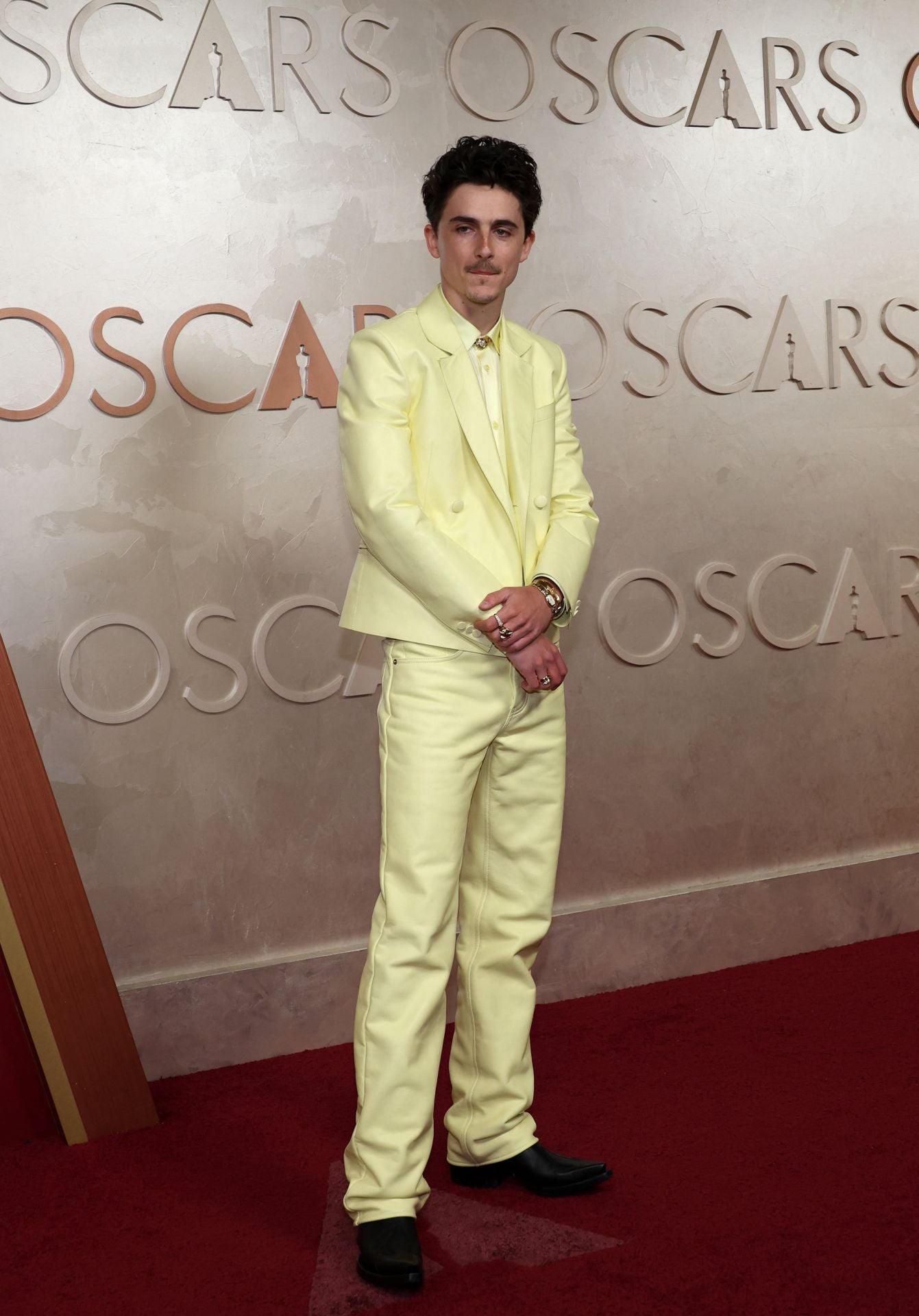 El actor Timothée Chalamet desafía a la mala suerte con un traje amarillo de chaqueta corta de Givenchy.