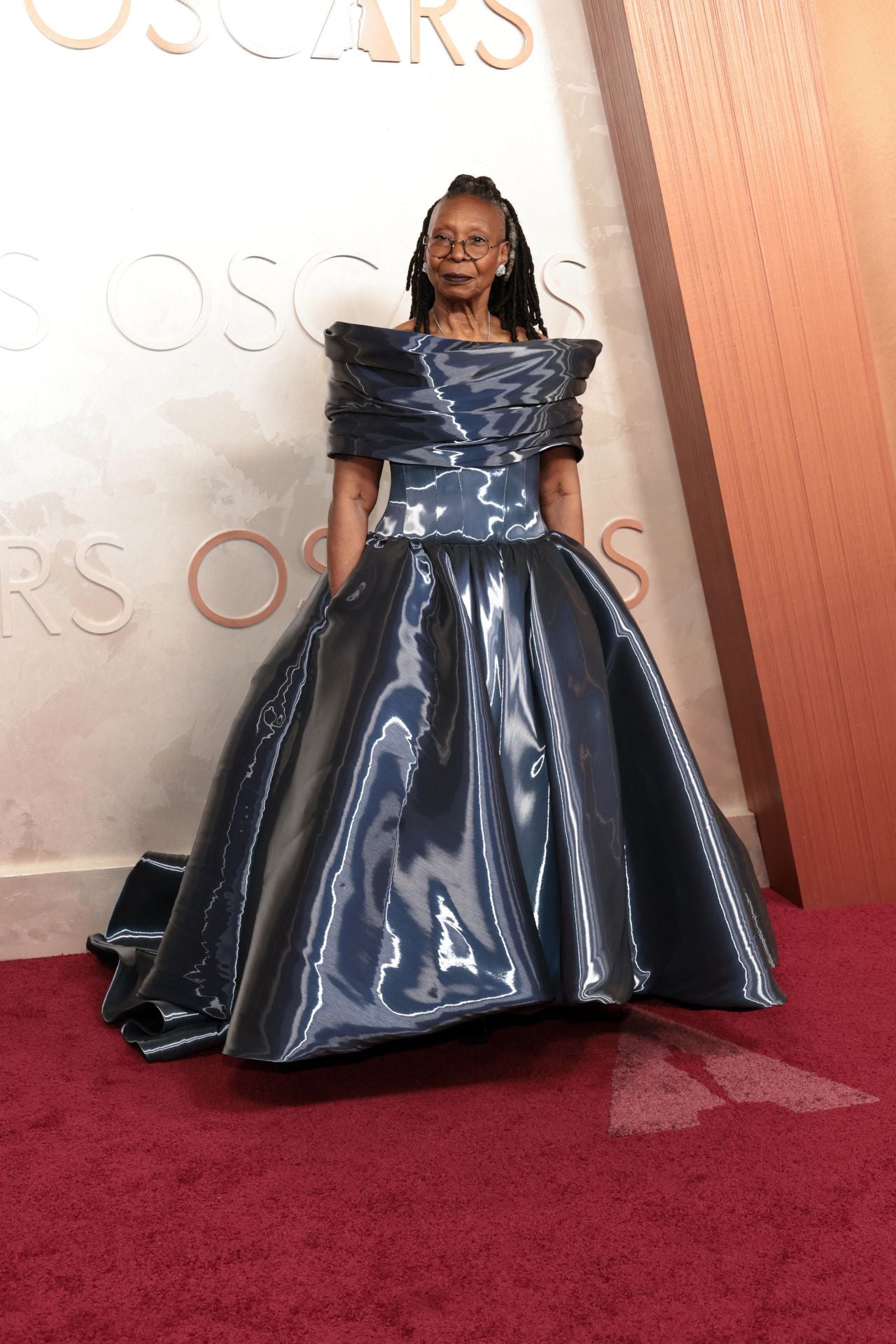 Whoopi Goldberg, una de las presentadoras de la noche, ha optado por una mezcla explosiva: escote barco tridimensional, cuerpo ceñido y falda corpulenta en este vestido de vinilo en gris de Christian Siriano.
