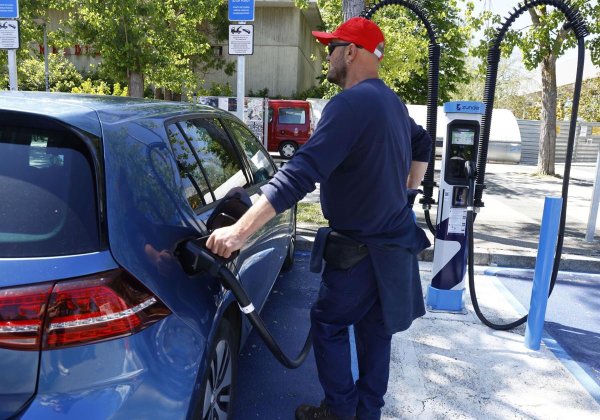 Un conductor recarga su coche eléctrico.
