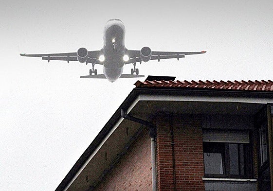 Un avión pasa sobre el tejado de una vivienda en Derio.