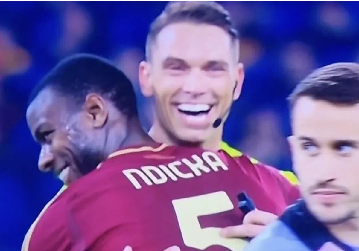 El árbitro suizo Sandro Scharer abraza cariñosamente a Ndicka.