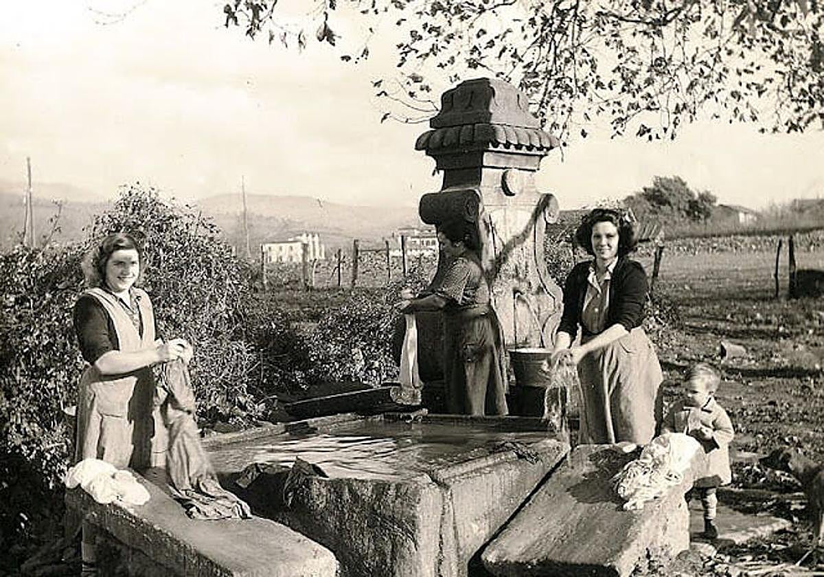 Feli Uribe junto a Nieves Urien y su hijo posan en 1949 en el lavadero público que construyó el cantero Roque Ereñaga