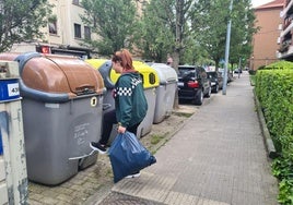 Una chica se dispone a depositar los residuos en su contenedor en Llodio.