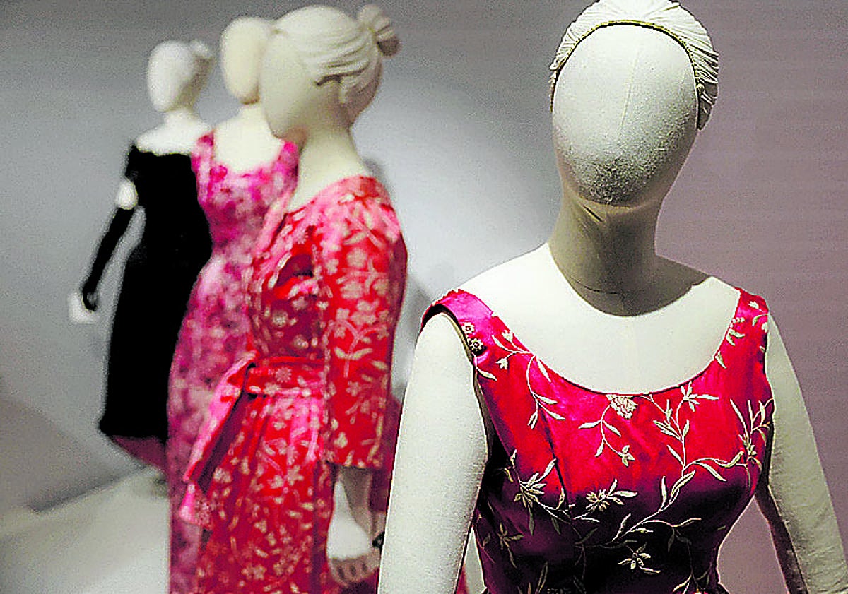 Imagen principal - Varios modelos de cóctel en tonos rojos. Chaqueta de noche en 'voluptuese', tejido estampado y con bandas de lamé, de Coudurier, Fructus y Descher. Vestido de novia en crepe satén de color marfil, regalo personal de Balenciaga a la hija del neurólogo donostiarra Benigno Oreja (1935). 