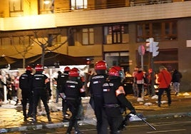 Un joven lanza un objeto a la Ertzaintza.